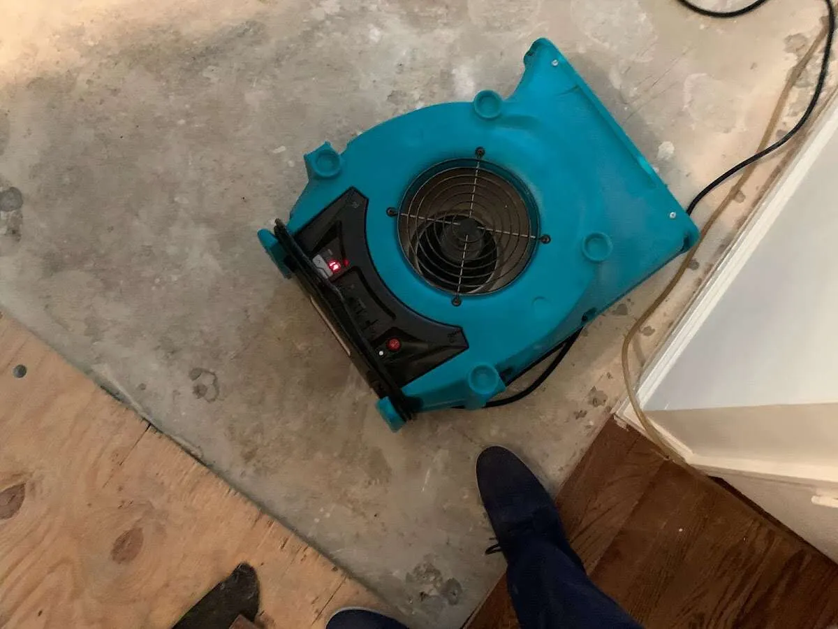 Air mover drying subfloor during Commercial Water Damage Restoration in Oskaloosa